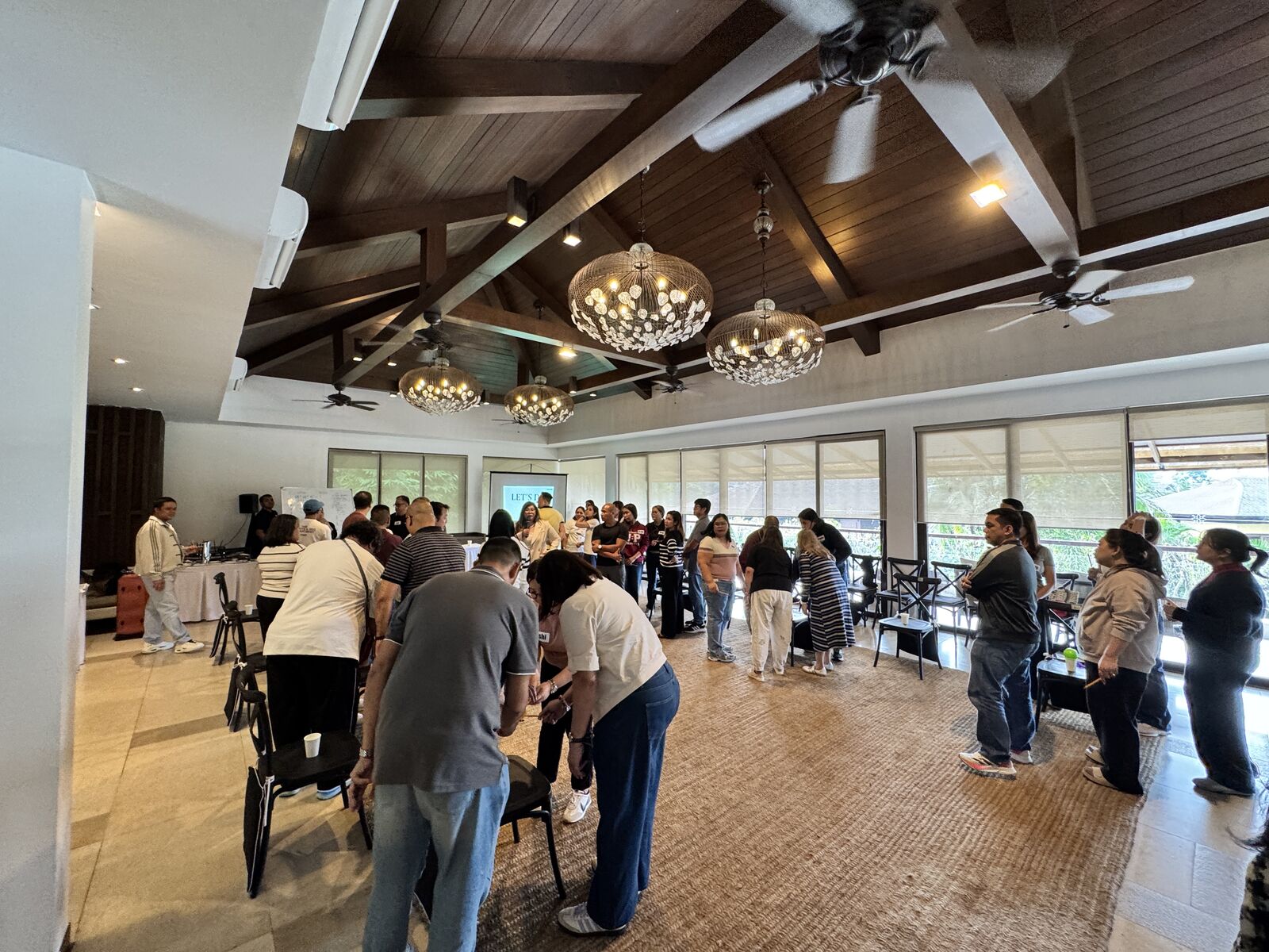 Wide view of the room in Tagaytay as eight teams of Global Payments leaders work through a HOPE in Action round