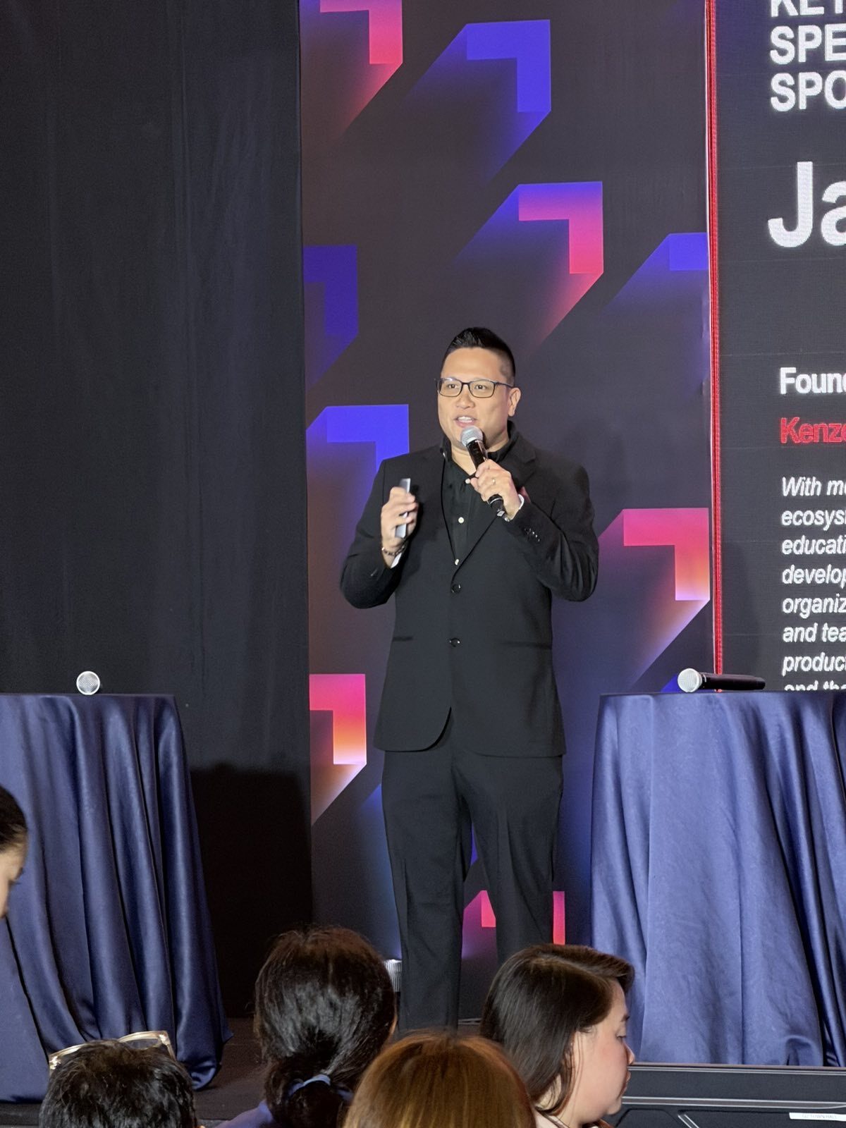Jay Jaboneta on stage delivering a keynote in front of a Keynote Speaker Spotlight screen at PGDC Leadership Connect 2026